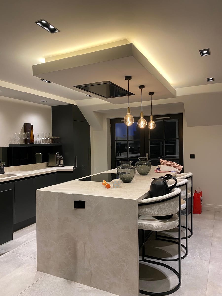 Kitchen island with pendant lights, an LED-lit ceiling raft and square downlights, wired by Mister Electrics