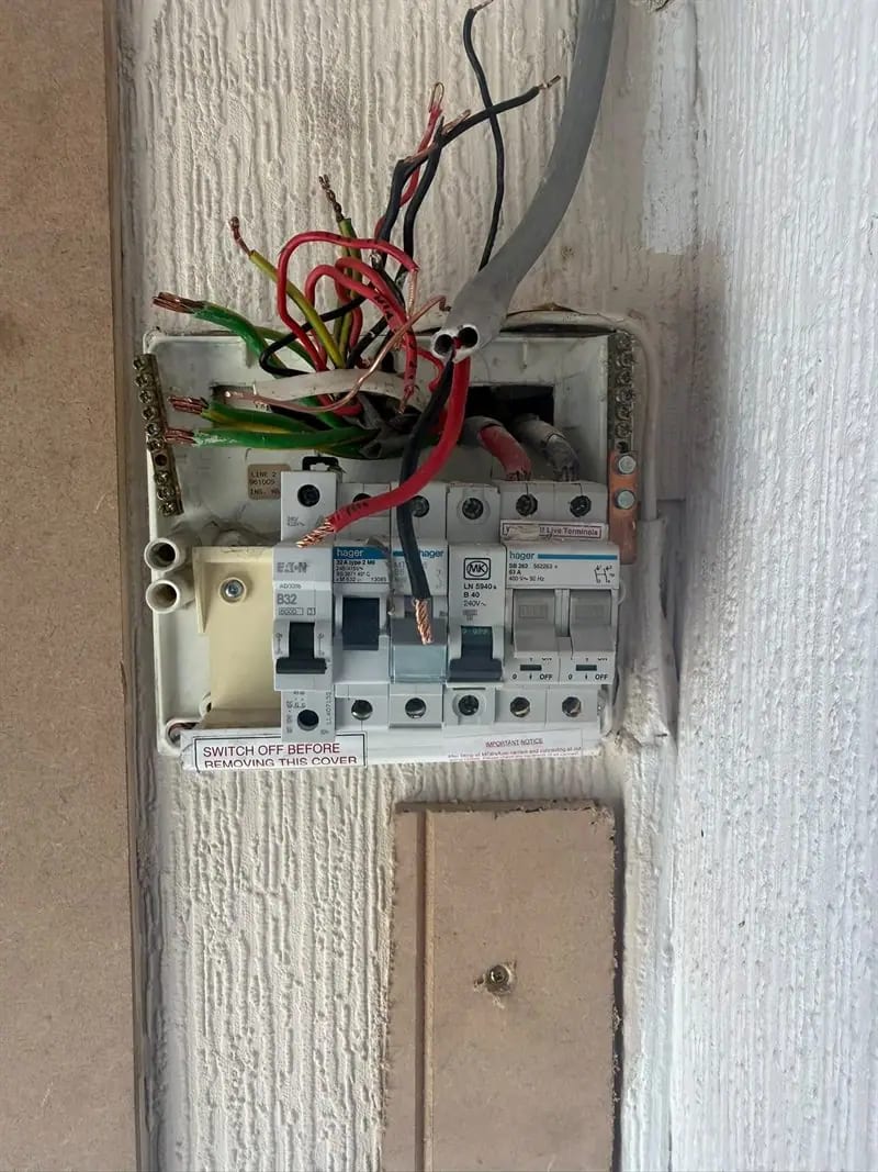 An ageing consumer unit on old red and black wiring, before replacement
